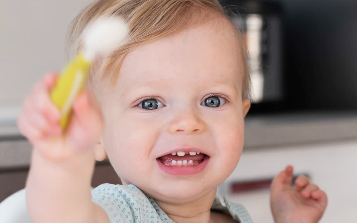 Bebê sorrindo com colher